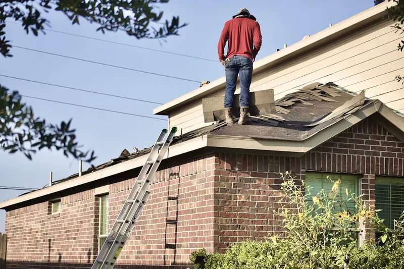Professional roofer working on a residential roof in Holland Patent